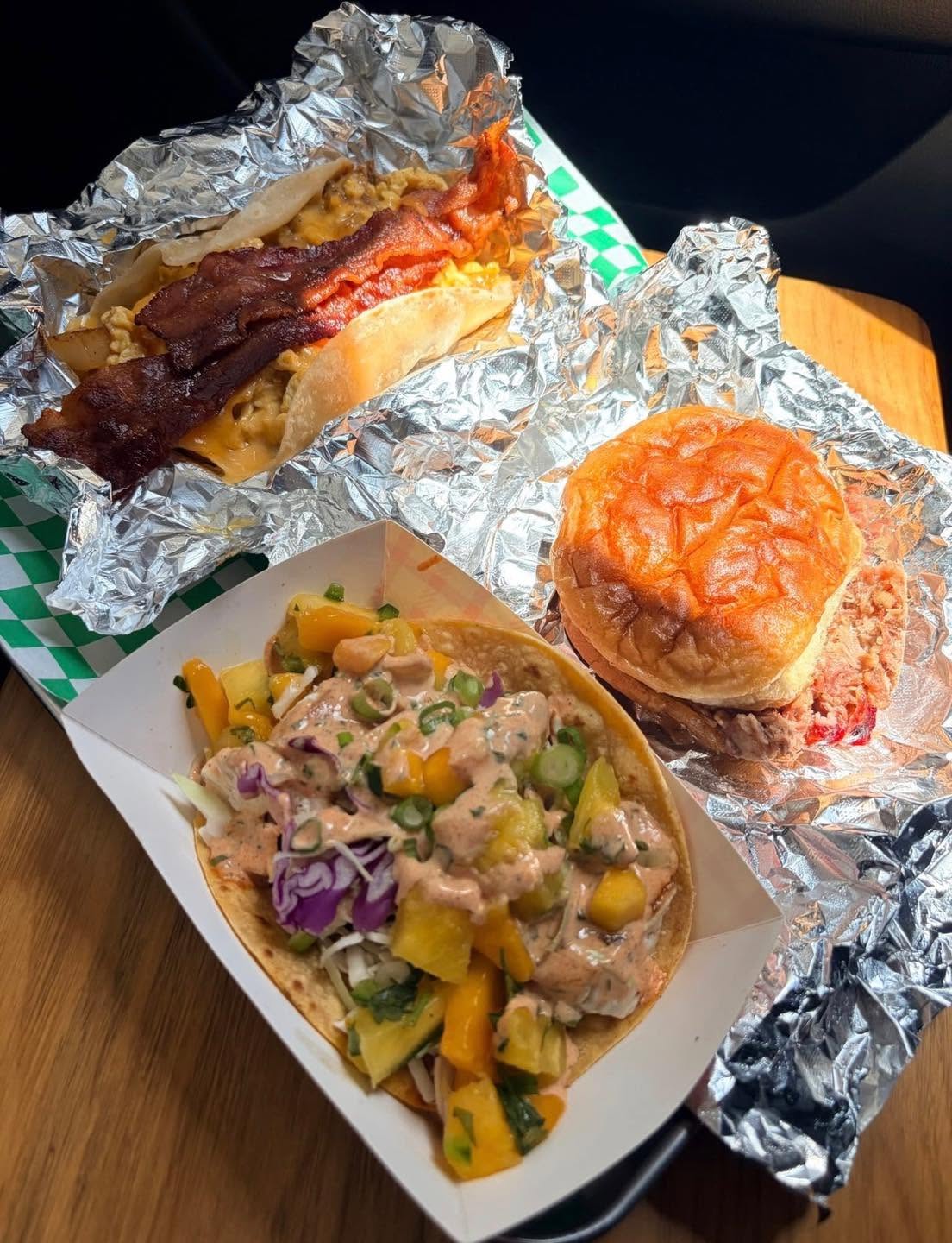 Breakfast taco, pork sandwich, and a taco topped with colorful salsa